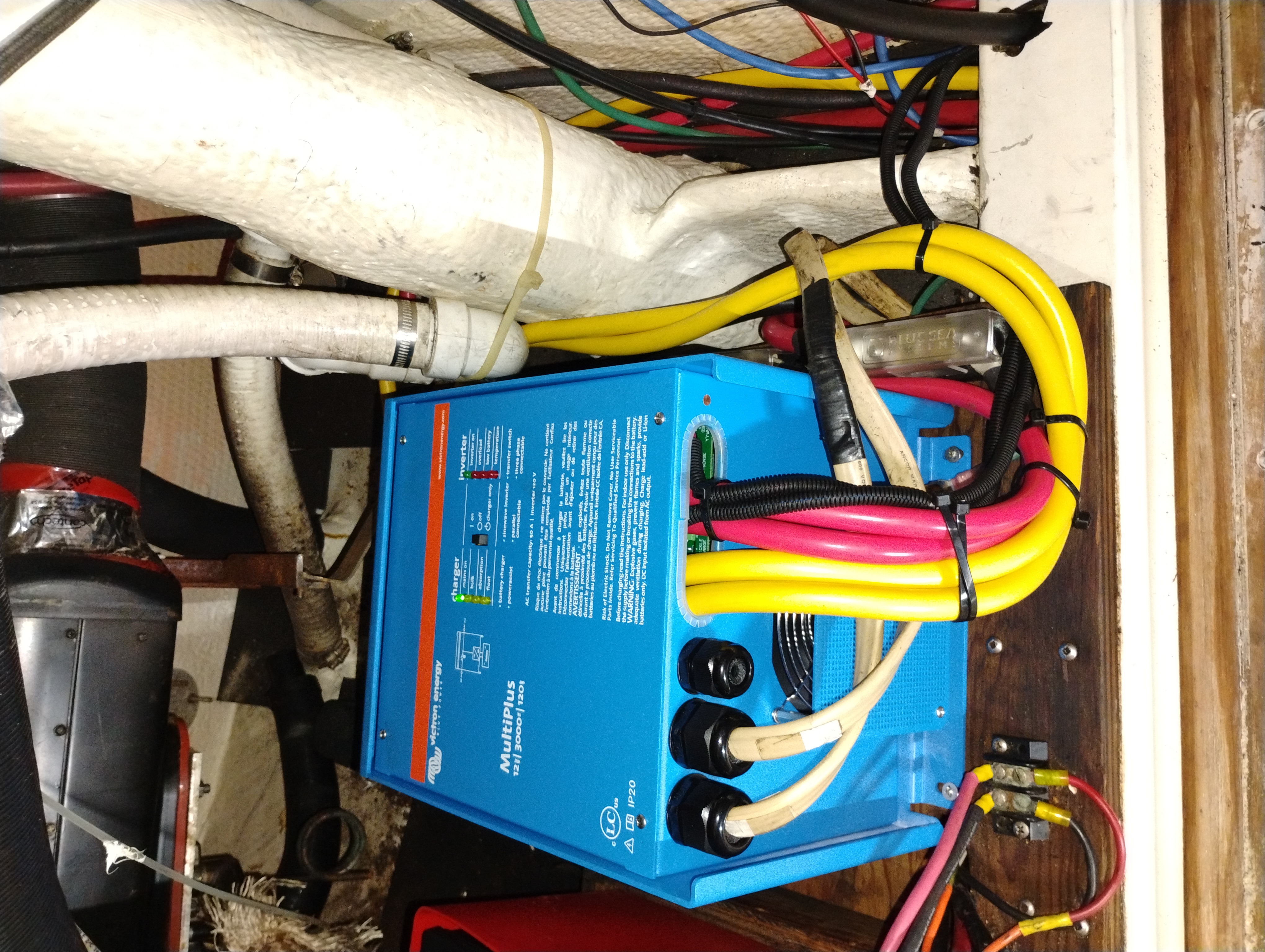 Victron MultiPlus inverter/charger installed in a boat engine bay with heavy-gauge terminal cables