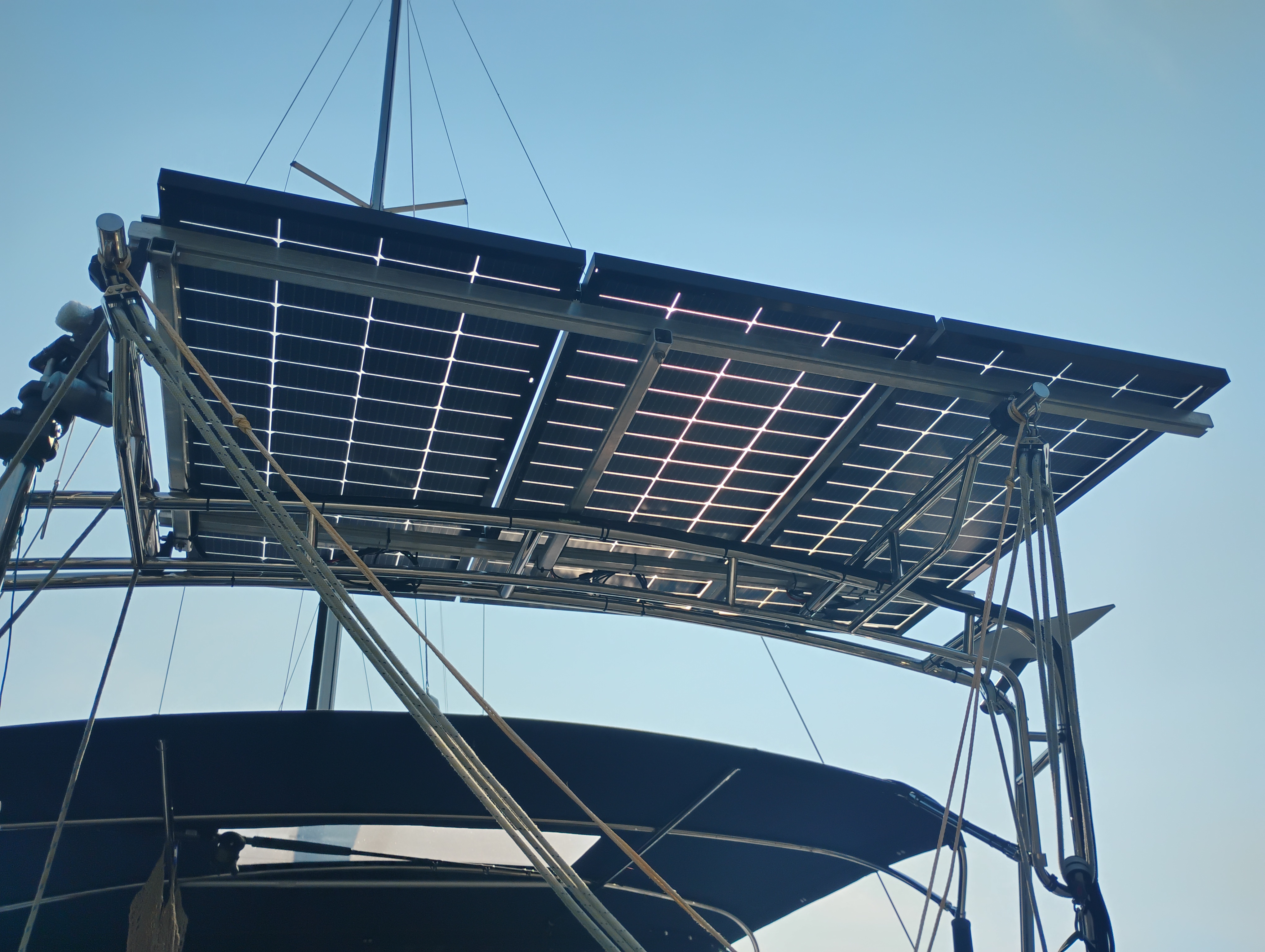 Solar panel mounted on a sailboat stern arch, viewed from the deck looking up
