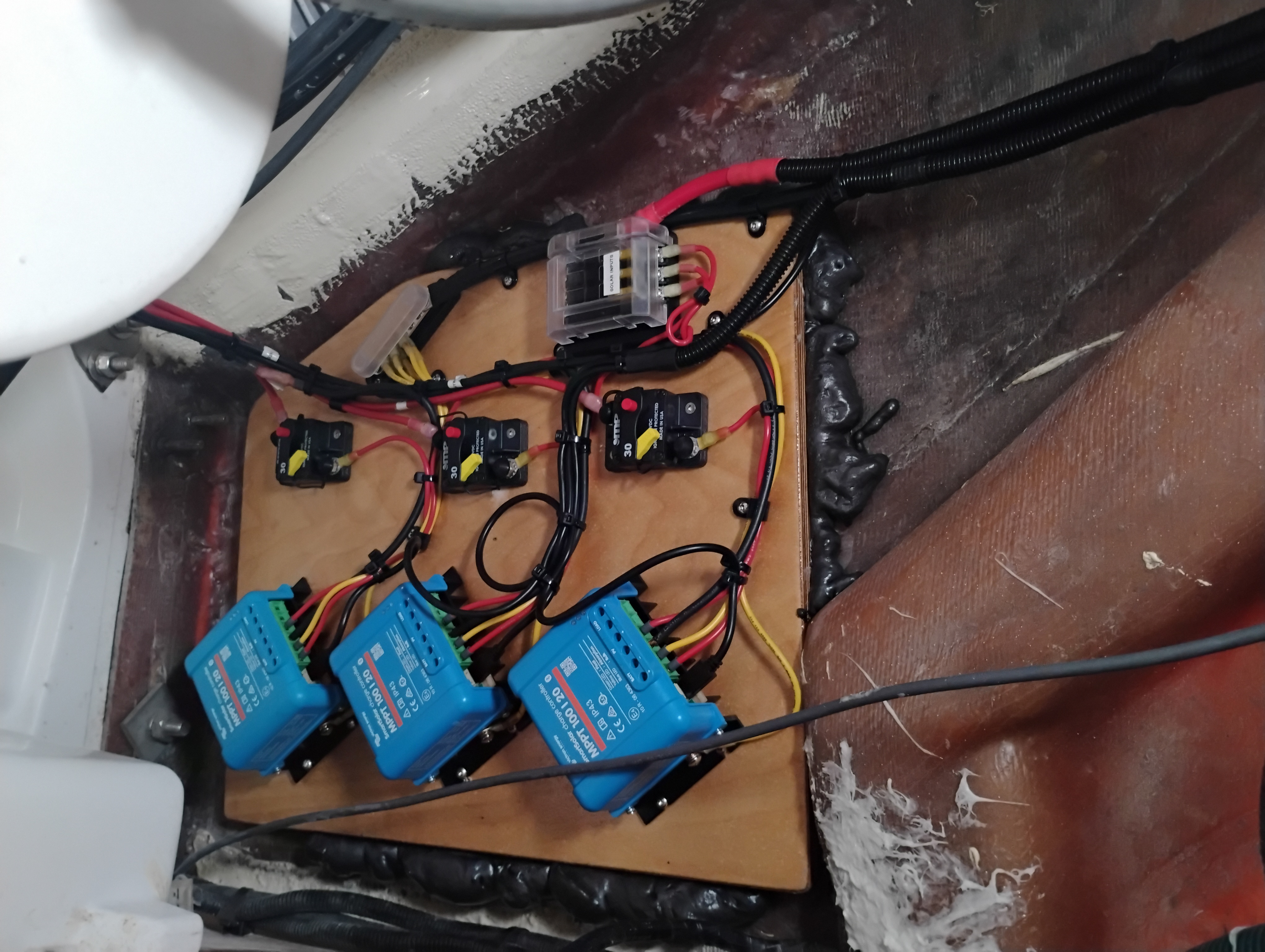 Victron MPPT solar charge controllers and DC distribution mounted on a marine install panel