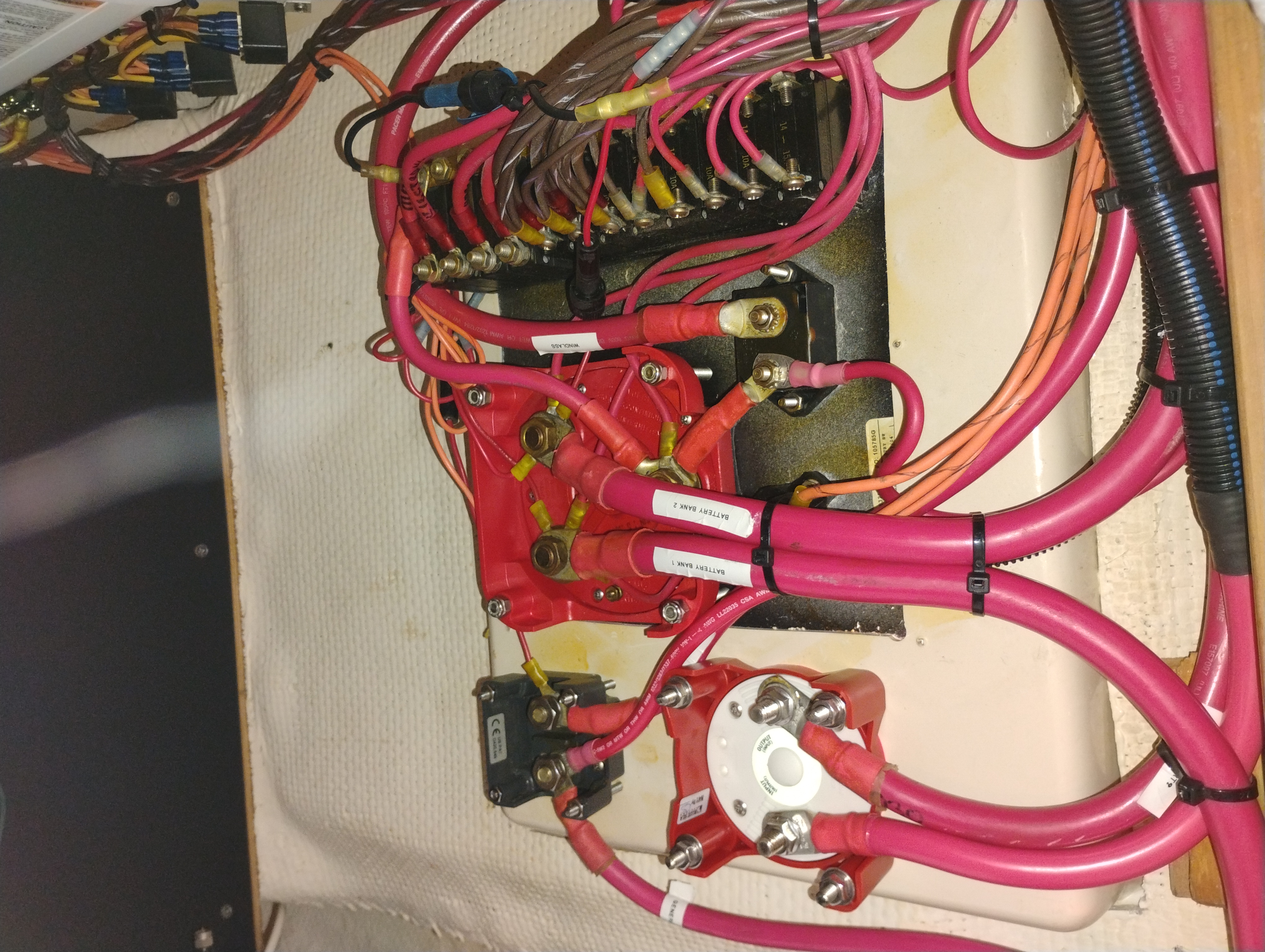 Marine electrical busbar with red marine-grade wires terminated using heat-shrink-insulated lugs